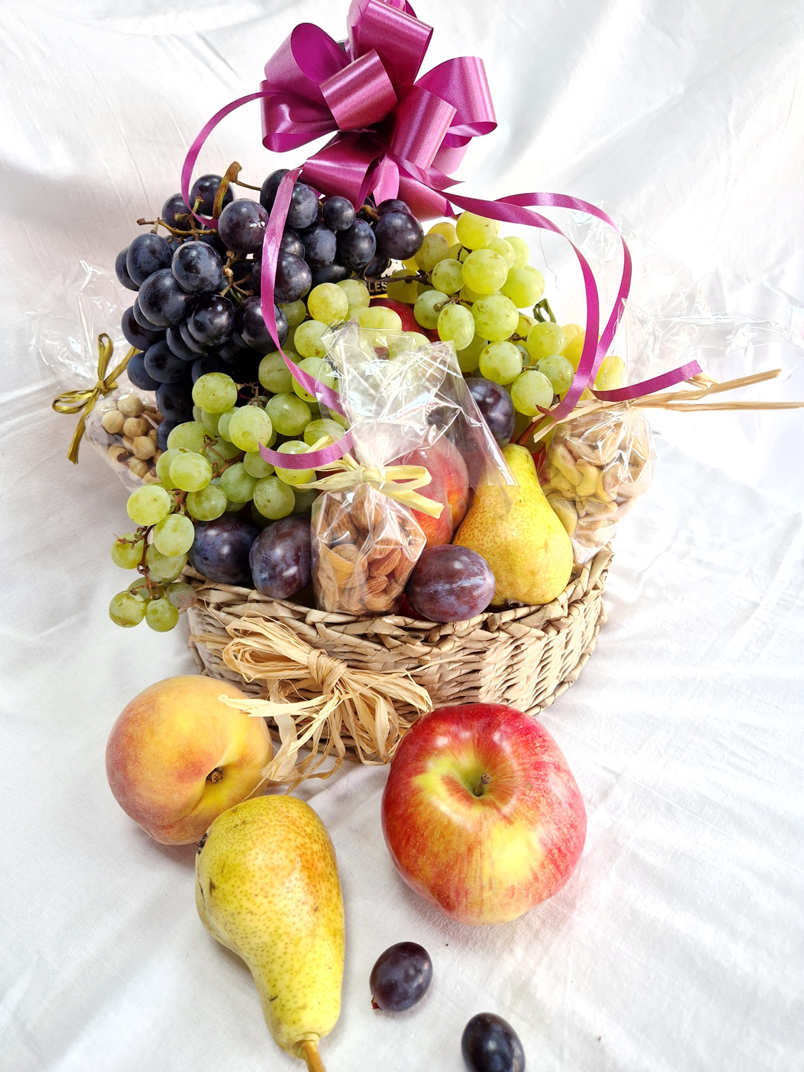 Hand-woven basket with fruit, grapes and champagne